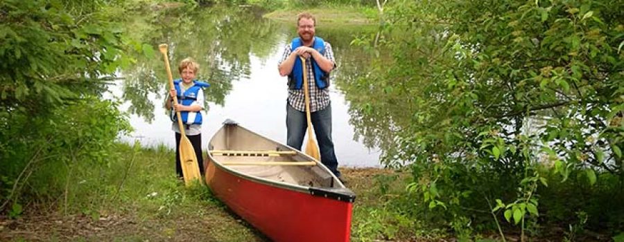 father and son with canoe and river