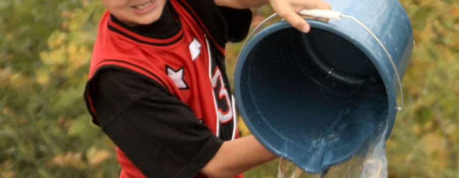 child pouring water from a bucket