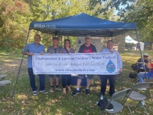 A group of volunteers hold up a Water Festival banner.